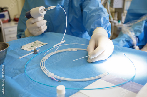 Doctor preparing instrument for vein surgery photo