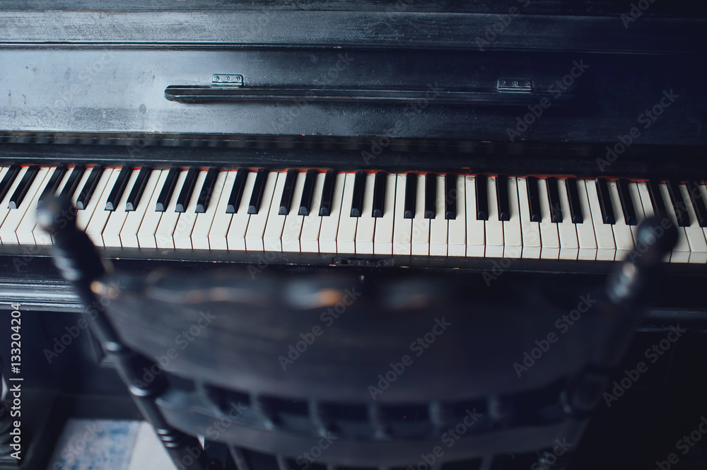 Black antique piano and a chair. General form Black antique piano and a chair. General form