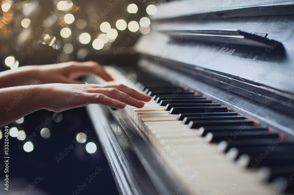 Naklejka premium dziewczyna gra na starym pianinie. Piękne rozmycie tła