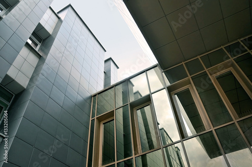 Look up at the modern facade of glass and wall panels.
