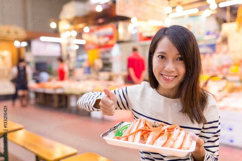Woman holding snow crab and showing thumb up Woman holding snow crab and showing thumb up