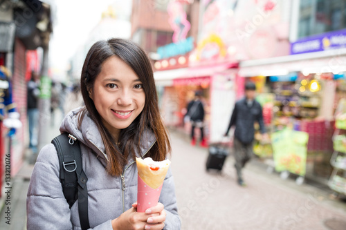 Woman holding a crape cake at street