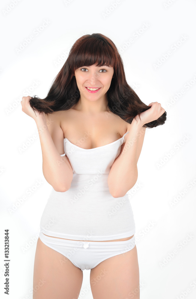Young long-haired brunette in white lingerie smiling on white background Young long-haired brunette in white lingerie smiling on white background
