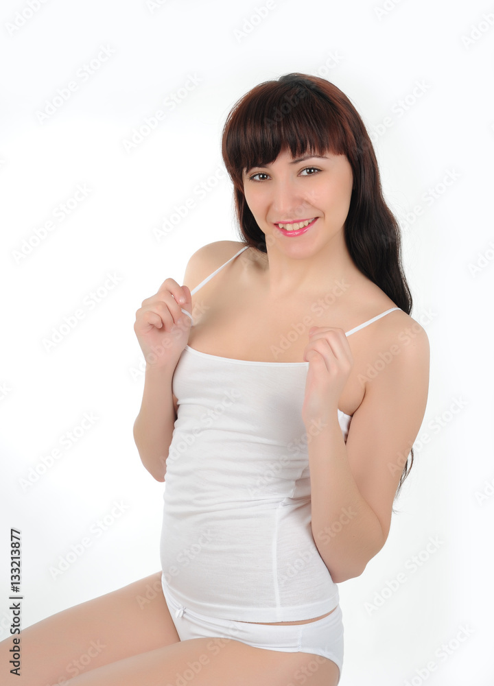 Young long-haired brunette in white lingerie smiling on white background Young long-haired brunette in white lingerie smiling on white background