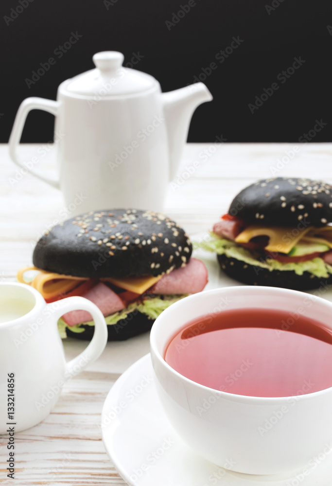 Fototapeta premium Black Hamburger , cup of tea and milk for breakfast.