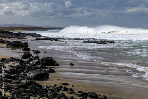 Massive waves, green turquoise colored, rolling in at a surf break on Fuerteventura Canary Islands.