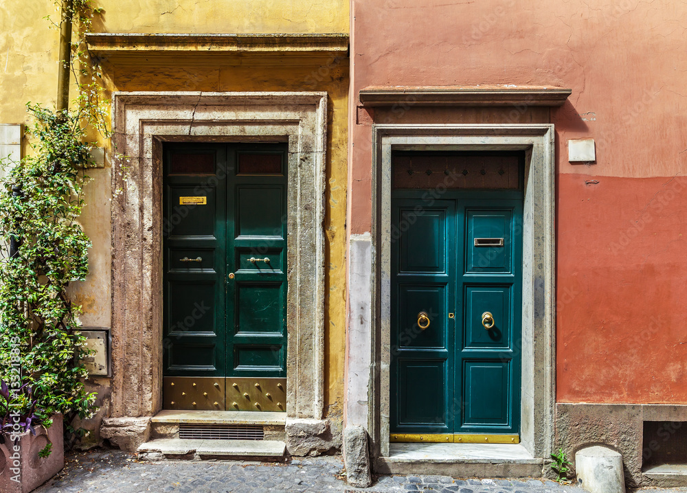Two classic Italian doors on walls painted blue and orange Two classic Italian doors on walls painted blue and orange