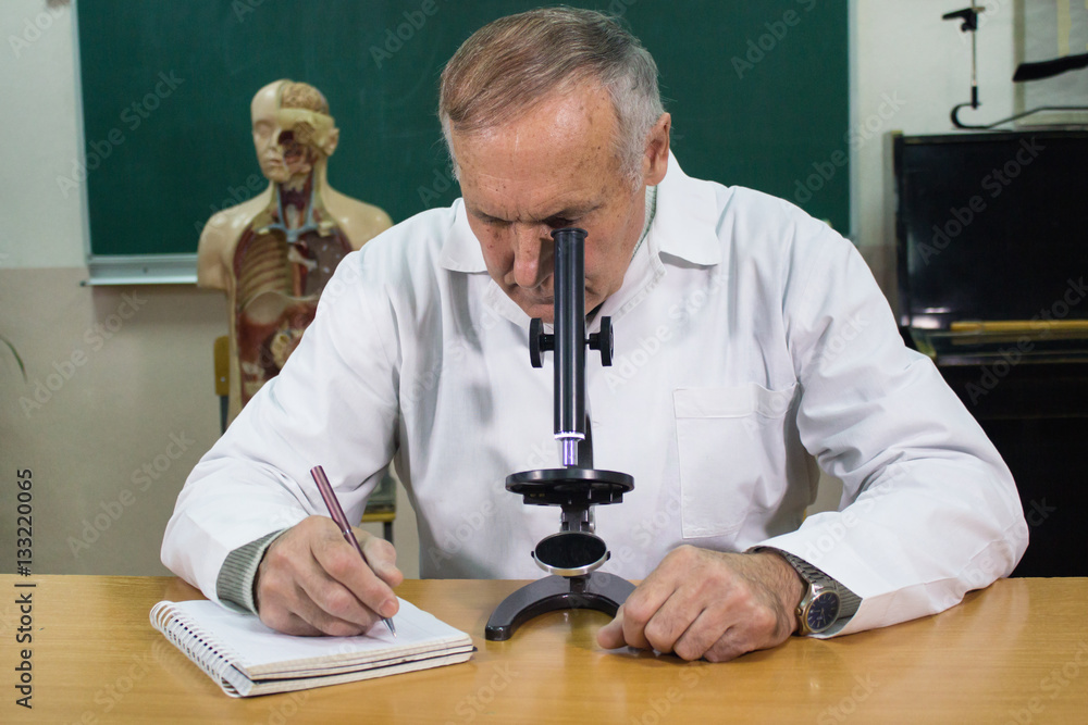 Closeup of Aged professor working with microscope Closeup of Aged professor working with microscope