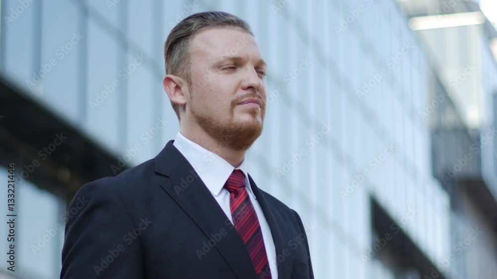 businessman standing near office building and expects to meet with a partner businessman standing near office building and expects to meet with a partner