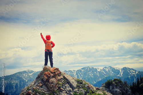 successful woman backpacker hiking on mountain peak cliff © lzf