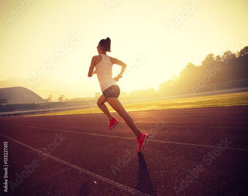 young fitness woman runner running on stadium track