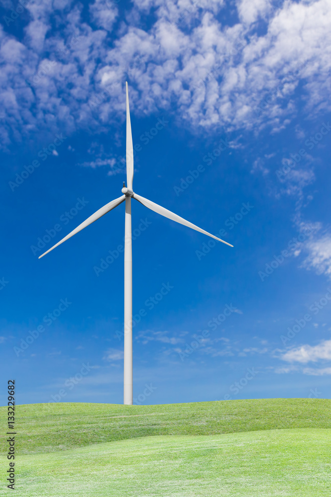 Fototapeta premium Wind turbine on grass field and blue sky