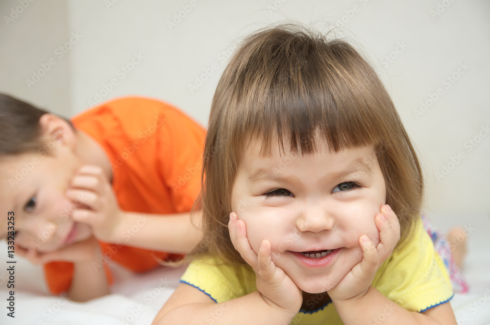 Happy kids, smiling little girl with cute cheeks and her brother Happy kids, smiling little girl with cute cheeks and her brother
