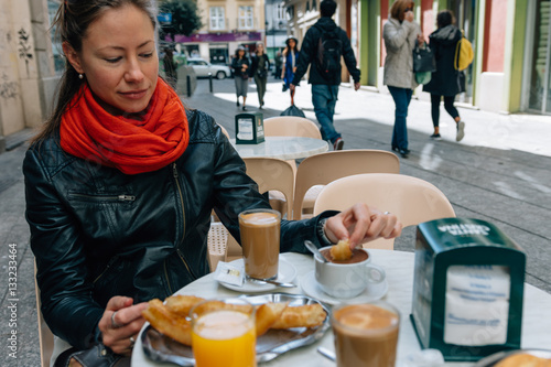 Young woman eating breakfast at street cafe