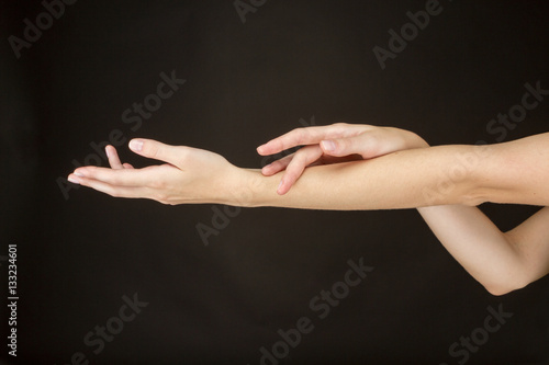 Женские руки на темном фоне.