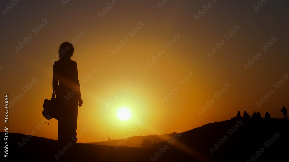 A woman standing in sunset