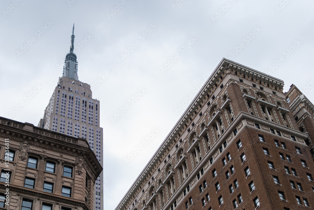Empire State Building rising over historic brick buildings