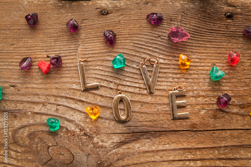 Love letters on wooden background with colorful stones. Valentines day concept.