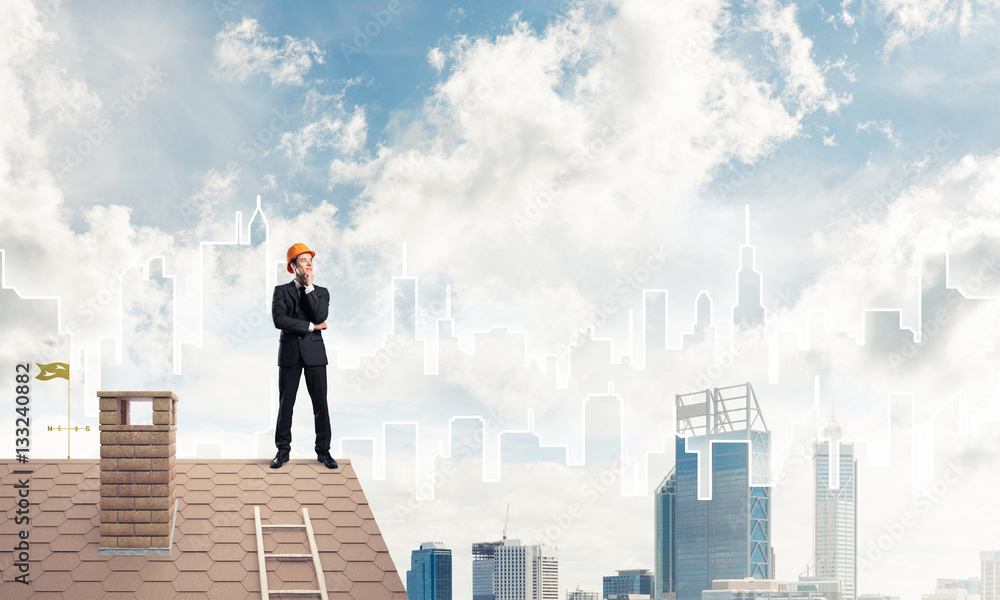 Engineer man standing on roof and looking away. Mixed media Engineer man standing on roof and looking away. Mixed media