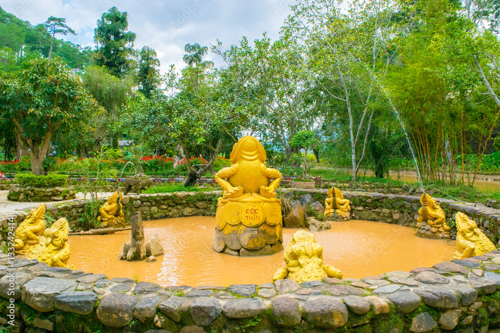 fountain with golden frogs with coins as a Landscape design of relax tropical garden