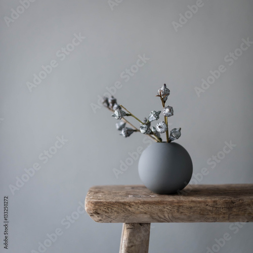 Vase on wooden table against gray wall
