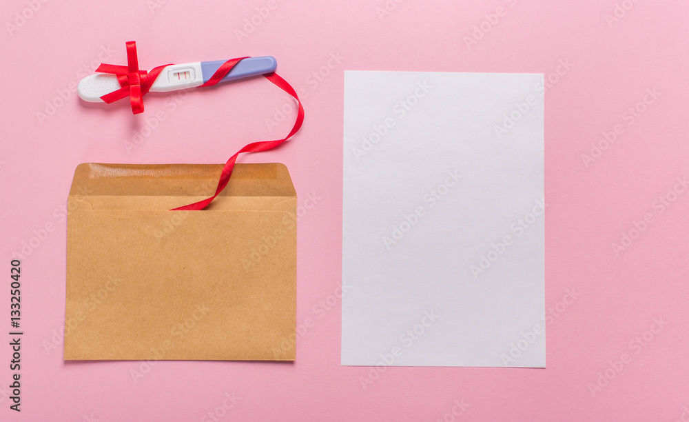 letter with a positive pregnancy test on a pink background letter with a positive pregnancy test on a pink background