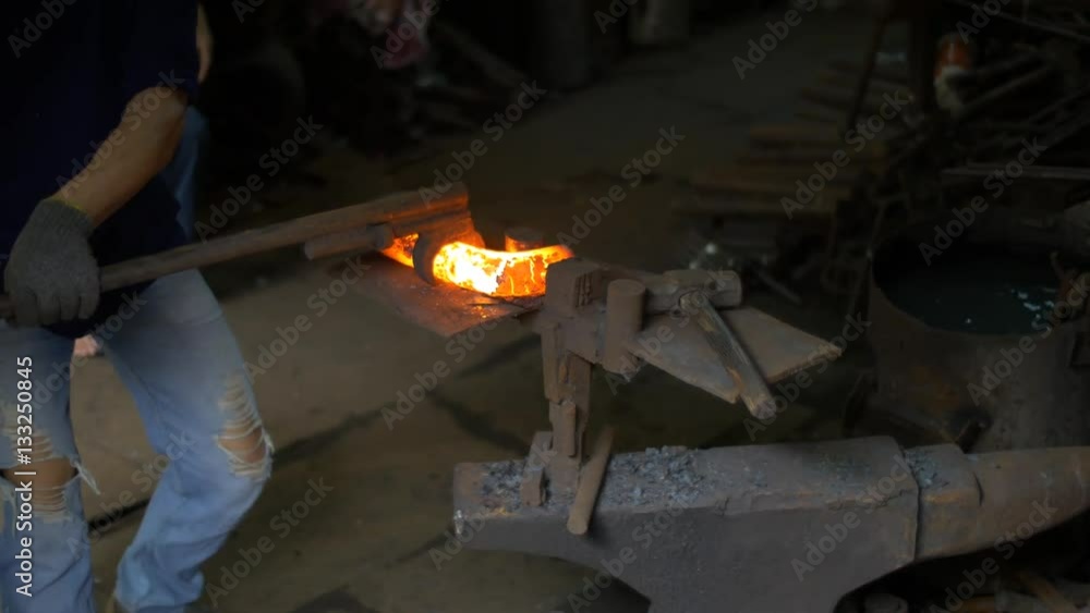 blacksmith working in smithery forging glowing hot metal blacksmith working in smithery forging glowing hot metal