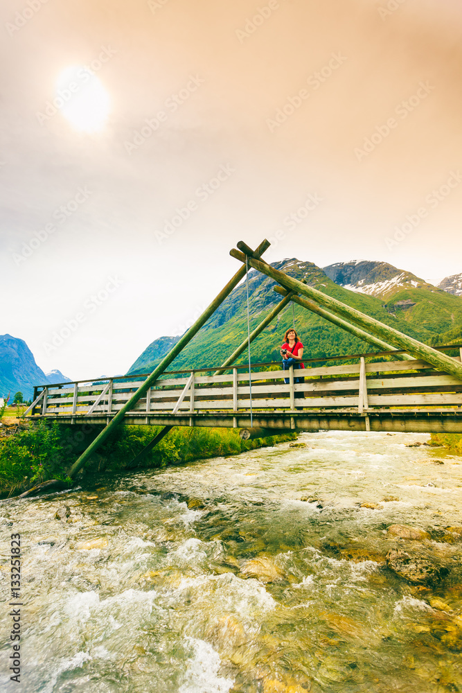Tourist relaxing on bridge in village Oppstryn Norway Tourist relaxing on bridge in village Oppstryn Norway