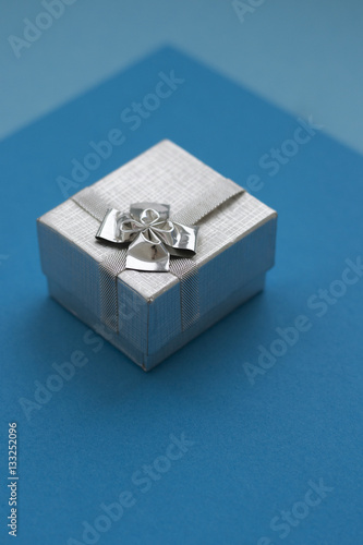 Silver gift box over blue background © FinchenkoInna