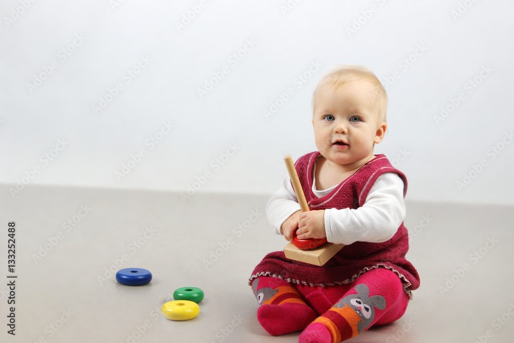 Shot of an adorable baby girl in red clothes playing with some wooden toys.
Shot of an adorable baby girl in red clothes playing with some wooden toys.