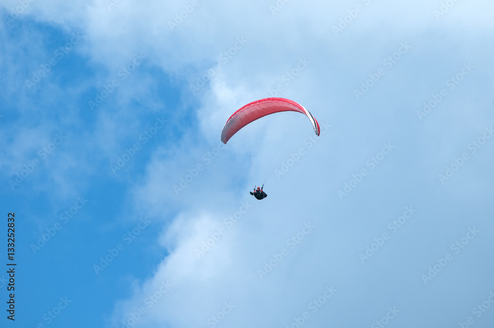 Paraglider flying in the sky. Paragliding. Paraglider flying near clouds.