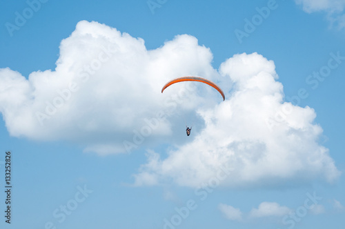 Paraglider flying in the sky. Paragliding. Paraglider flying near clouds.