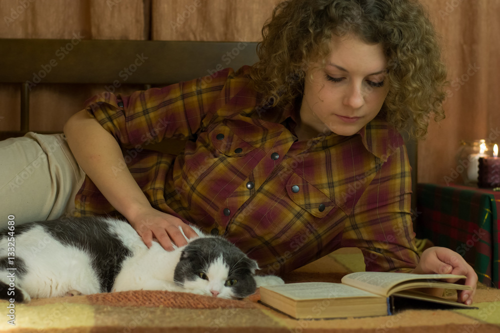 Girl and a cat reading an open book Girl and a cat reading an open book