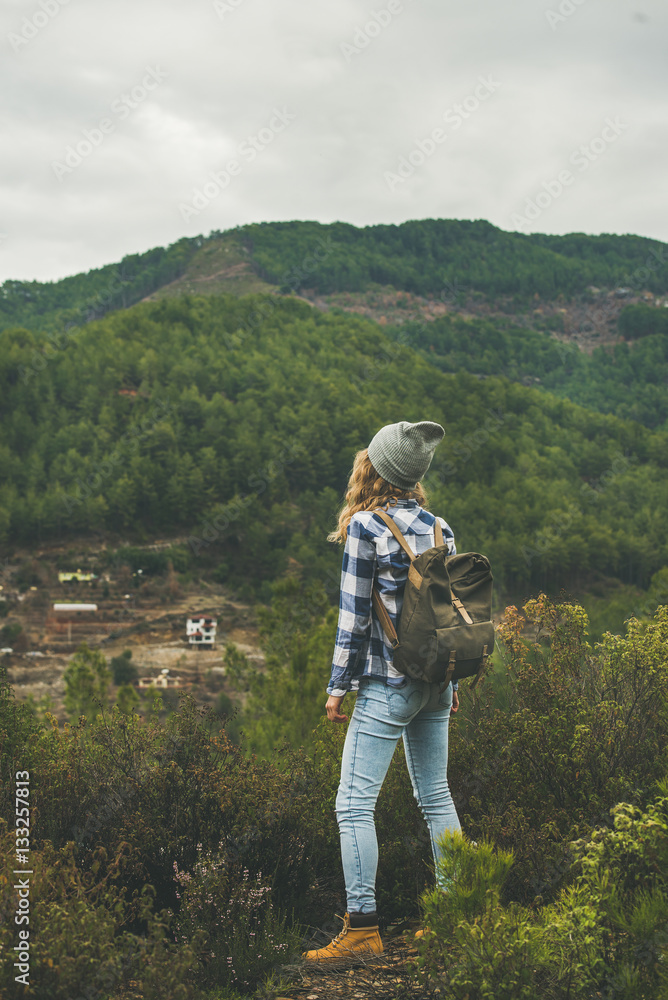 Young woman traveler in chekered shirt and blue jeans hiking in mountains, Dim Cay district of Alanya, Antalya province, Mediterranean Turkey