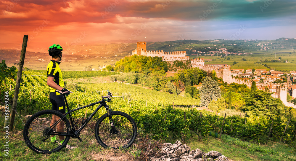 Fototapeta premium Cyclist admires the Soave castle views.