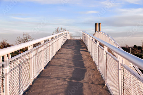 Inner perspective view of modern white bridge over sky background