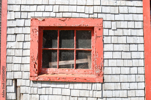 Window with peeling red paint in an old sea shanty photo