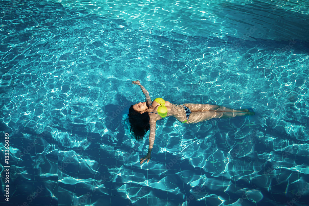 Sexy
tanned woman in pool water bikini model
