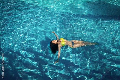 Sexy tanned woman in pool water bikini model