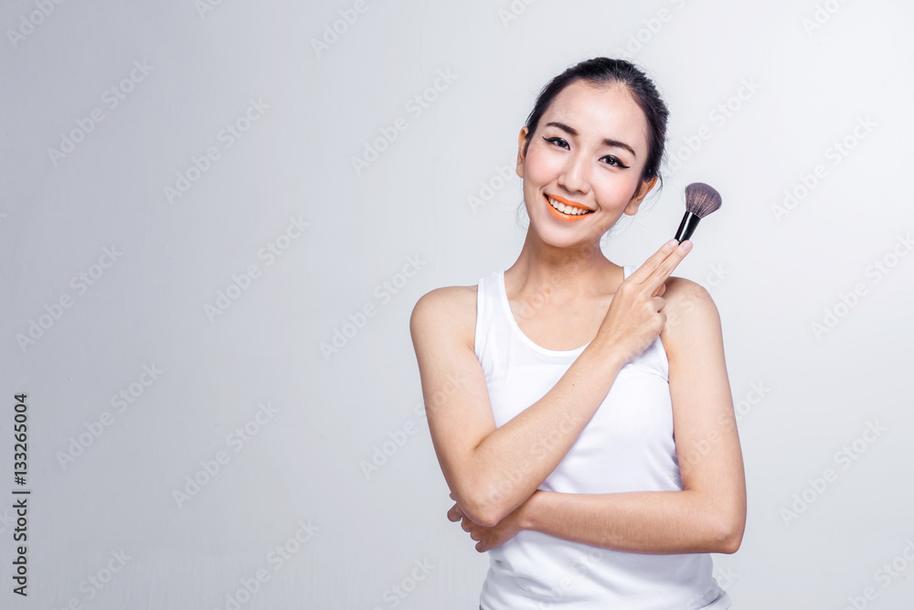 Asian woman holding brushes - beauty makeup concept Asian woman holding brushes - beauty makeup concept