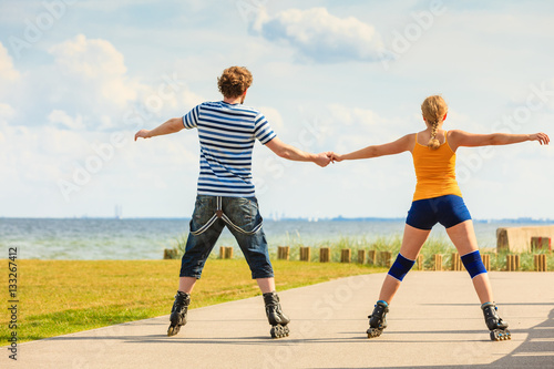 Young couple on roller skates riding outdoors