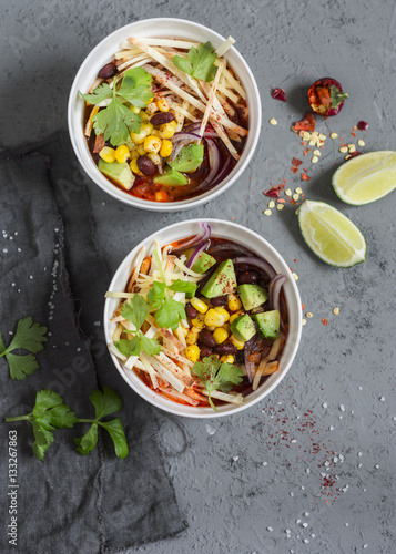 Mexican chicken tortilla soup with corn, beans and avocado. Delicious lunch, top view
