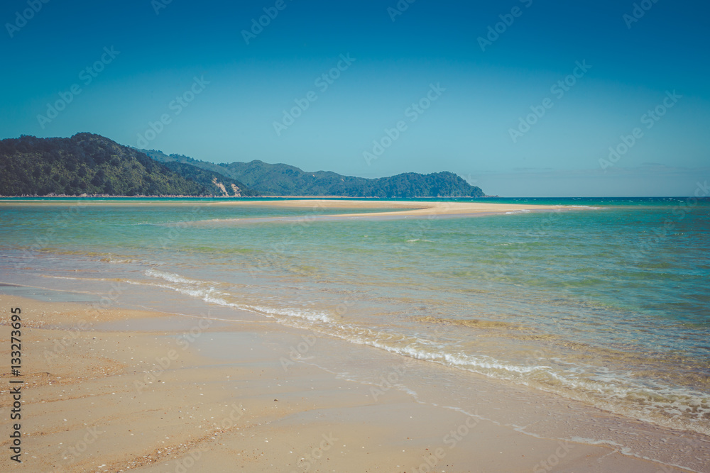 Fototapeta premium Beautiful dreamy ocean landscape with clear sky and gentle waves of the ocean, Abel Tasman National Park, New Zealand