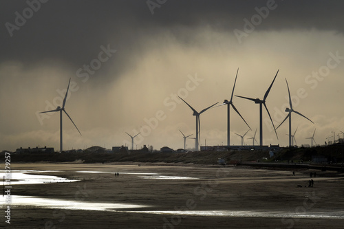 Tableau sur toile Wind turbines near coastal houses in poor weather
