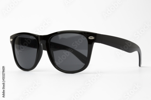 Cool sunglasses with black plastic frame isolated on white background, top view