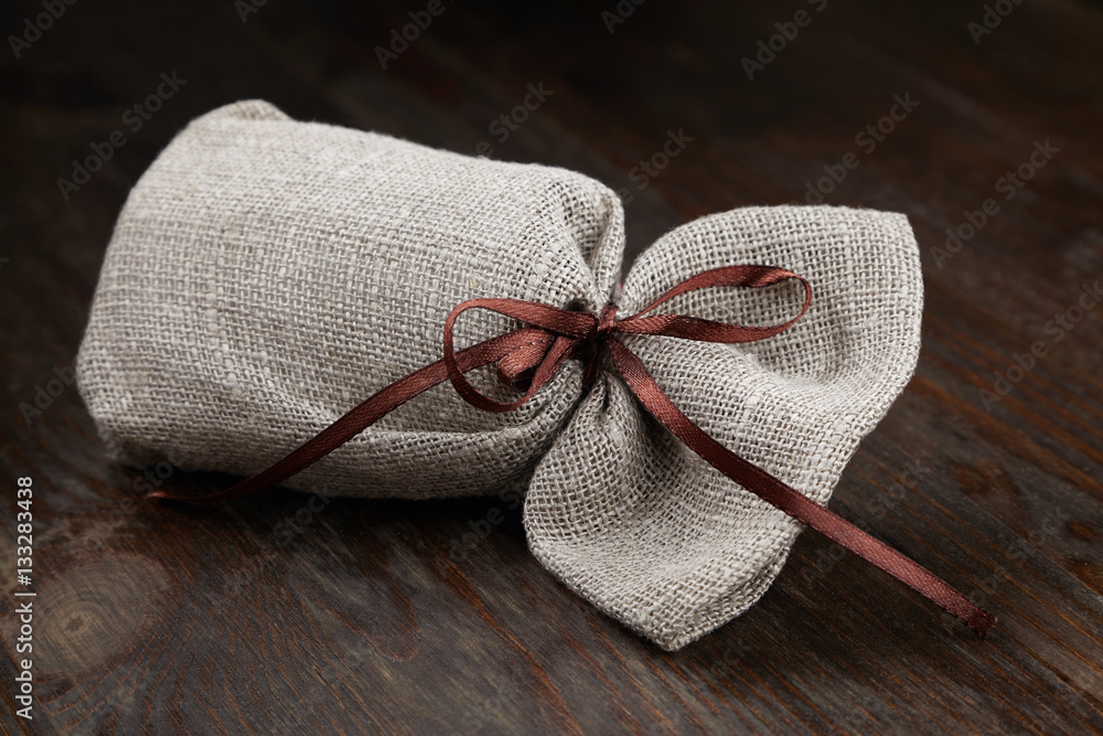 cloth bag with a gift, a pleasant surprise on dark baground