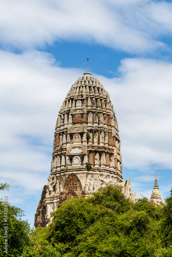 The central prang of wat Ratchaburana rises in majestic fashion high above the treeline in Thailand's Ayutthaya historical park, a UNESCO world heritage site.