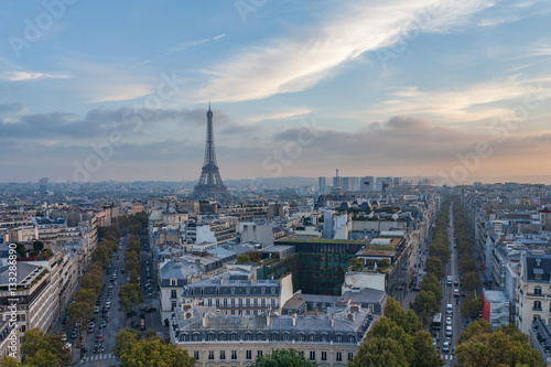 View from Arc de Triomphe in Paris, France towards Eiffel Tower with skyline, blue sky and traffic