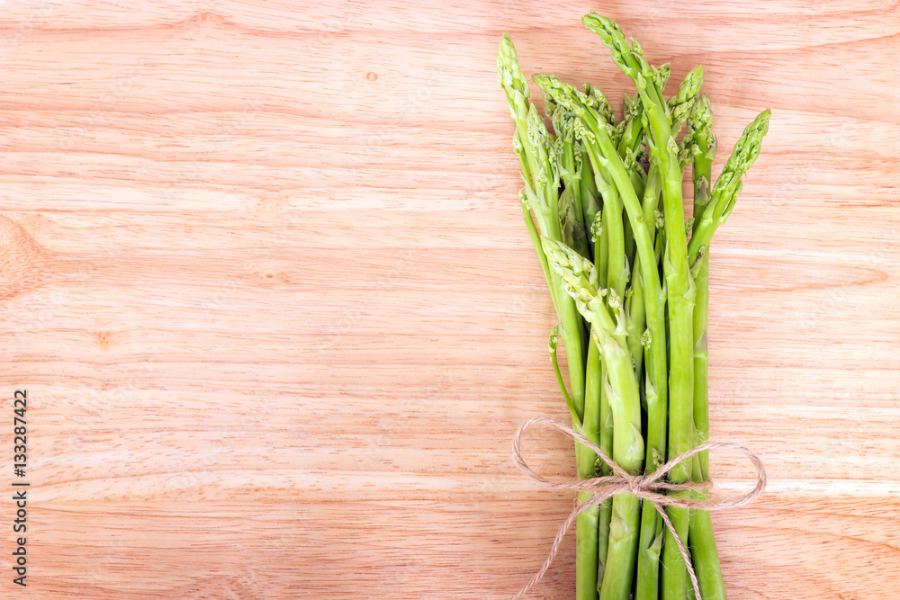 Bunch of fresh asparagus on a rustic wooden table Bunch of fresh asparagus on a rustic wooden table