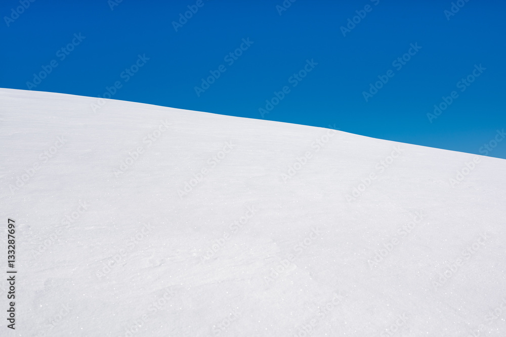 Simple winter landscape. Winter natural background of pure snow with blue sky. 
